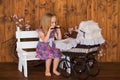 Pretty little girl play with retro pram, baby stroller