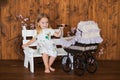 Pretty little girl play with retro pram, baby stroller