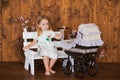 Pretty little girl play with retro pram, baby stroller