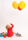 Pretty little girl is playing with balloons on a white background Royalty Free Stock Photo