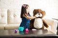 Cute little girl playing tea party with teddy bear Royalty Free Stock Photo