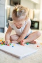 Pretty little girl playing with mushroom nail mosaic at home. Hobby and leisure time Royalty Free Stock Photo