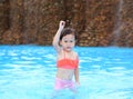 Pretty little girl playing in swimming pool outdoors Royalty Free Stock Photo