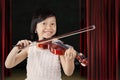 Pretty little girl plays violin on the stage