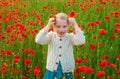 Pretty little girl on a poppy field, outdoor. Child girl in a field of red poppies enjoys nature. Little daughter in the Royalty Free Stock Photo