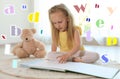 Pretty girl reading book on floor in room Royalty Free Stock Photo