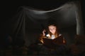 A pretty little girl reading a book on the floor under the lamp. Children and education Royalty Free Stock Photo