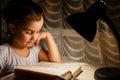 A pretty little girl reading a book on the floor under the lamp children and education Royalty Free Stock Photo