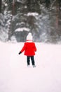 Pretty little girl in red coat in winter forest. Little girl having fun on winter day Royalty Free Stock Photo