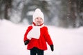 Pretty little girl in red coat in winter forest. Little girl having fun on winter day Royalty Free Stock Photo