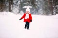 Pretty little girl in red coat in winter forest. Little girl having fun on winter day Royalty Free Stock Photo