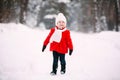 Pretty little girl in red coat in winter forest. Little girl having fun on winter day Royalty Free Stock Photo