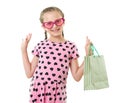 Pretty little girl with shopping bag, studio portrait, dressed in pink with heart shapes, white background Royalty Free Stock Photo