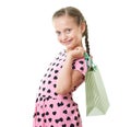 Pretty little girl with shopping bag, studio portrait, dressed in pink with heart shapes, white background Royalty Free Stock Photo