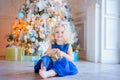 Pretty little girl sitting near christmas tree. Royalty Free Stock Photo