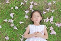 Pretty little girl sleeping on green grass with fall pink flower in the garden outdoor Royalty Free Stock Photo