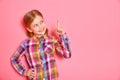 Pretty little girl standing with raised finger up. Copy space. Royalty Free Stock Photo