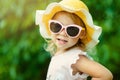 Pretty little girl in a striped dress and hat relaxing on the beach near sea, summer, vacation, travel concept. smiling Royalty Free Stock Photo