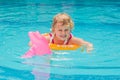 Pretty little girl swimming in outdoor pool and have a fun with inflatable circle Royalty Free Stock Photo