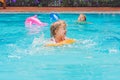 Pretty little girl swimming in outdoor pool and have a fun with inflatable circle Royalty Free Stock Photo