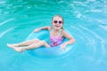 Pretty little girl swimming in outdoor pool and have a fun with inflatable circle Royalty Free Stock Photo