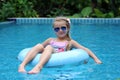 Pretty little girl swimming in outdoor pool and have a fun with inflatable circle Royalty Free Stock Photo