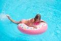 Pretty little girl swimming in outdoor pool and have a fun with inflatable circle Royalty Free Stock Photo