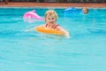 Pretty little girl swimming in outdoor pool and have a fun with inflatable circle Royalty Free Stock Photo