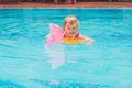 Pretty little girl swimming in outdoor pool and have a fun with Royalty Free Stock Photo