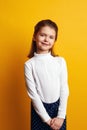 Pretty little girl in white turtleneck posing adorably on yellow background Royalty Free Stock Photo