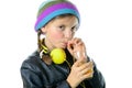 a pretty little girl with a woolen cap drinking a glass of orange juice Royalty Free Stock Photo