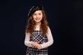 Stylish brunette kid is posing in studio on a black background. Children`s fashion. Royalty Free Stock Photo