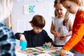 Pretty little kids folding details of constructor on desk in playroom closeup. Interesting game for kindergartners Royalty Free Stock Photo