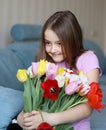 Pretty little shy girl holding big bouquet of tulips Royalty Free Stock Photo