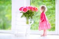 Pretty little toddler girl playing with peony flowers Royalty Free Stock Photo