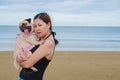 Pretty lonely asia girl hold cute dog puppy pug against beach , sea and blue sky background and smile to camera. Royalty Free Stock Photo