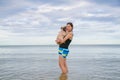Pretty lonely asia girl hold cute dog puppy pug against beach , sea and blue sky background and smile to camera. Royalty Free Stock Photo