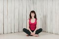 A girl in a pink top, sitting cross-legged on the floor, light b Royalty Free Stock Photo