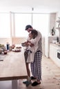 Pretty long-haired young woman in a white shirt and her husband talking in the kitchen Royalty Free Stock Photo