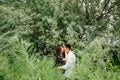 Beautiful loving couple resting in summer field on green grass and oleaster tree background