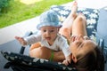 Pretty loving mom trying to soothe scarred crying baby in mother`s arms outdoor at sun deck chair