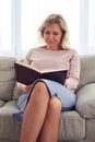 Pretty madam smiling while concentrating on reading book Royalty Free Stock Photo