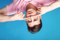 Pretty man with flowers under his eyes, wearing pink clothes. Boy on blue background with serious emotions, thinking about Royalty Free Stock Photo