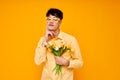 pretty man in yellow glasses with a bouquet of flowers yellow background unaltered Royalty Free Stock Photo