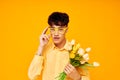 pretty man in yellow glasses with a bouquet of flowers yellow background unaltered Royalty Free Stock Photo