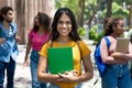 Pretty mexican female student with group of latin american and caucasian and african young adults Royalty Free Stock Photo