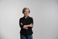 Pretty mid aged grey haired woman in black shirt isolated on grey background. Confident mature grey haired woman looking Royalty Free Stock Photo