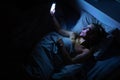 Pretty, middle-aged woman using her cell phone in bed Royalty Free Stock Photo