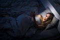Pretty, middle-aged woman using her cell phone in bed Royalty Free Stock Photo