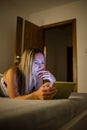 Pretty, middle-aged woman using a tablet computer in bed Royalty Free Stock Photo